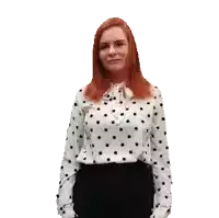 a woman with red hair is wearing a polka dot shirt and black pants