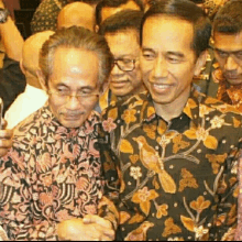 two men in floral shirts are posing for a photo