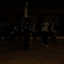 a group of young men are standing on a wooden floor and one of them is wearing a sweater that says breath