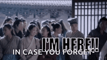 a group of people standing next to each other with the words " i 'm here in case you forget "