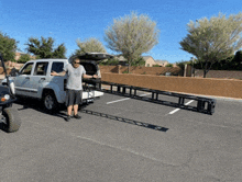 a man standing in front of a white truck with a ladder in the back