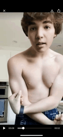 a young man without a shirt is flexing his muscles in a video .