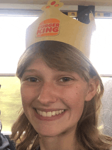 a young girl wearing a burger king crown smiles for the camera