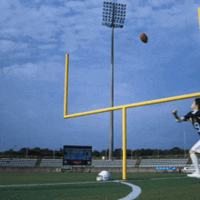 a football player jumps to catch a ball in front of a scoreboard that says ' texas tech ' on it