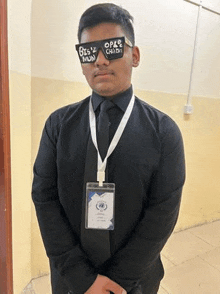 a man wearing sunglasses and a name tag is standing in a room .