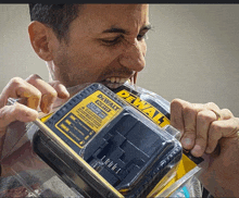 a man bites into a dewalt charger in a plastic package