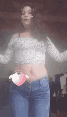 a woman wearing a crop top and jeans has a pink heart on her waist