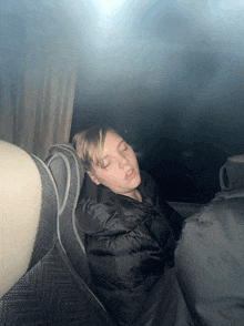 a person sleeping in a car with their eyes closed and their mouth open