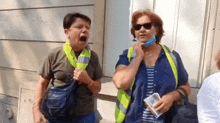 two women are standing next to each other and one is wearing a mask