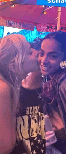 a woman is kissing another woman on the cheek while standing next to each other .