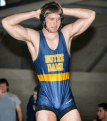 a wrestler wearing a blue and yellow singlet that says notre dame on it