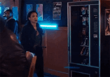 a woman is standing in front of a vending machine .