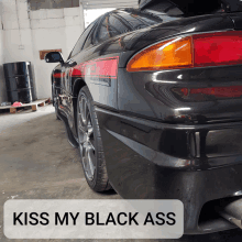 a black car with the words kiss my black ass written on the bottom