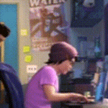 a girl in a purple shirt is typing on a laptop