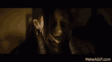 a close up of a woman 's face in a dark room in a movie .