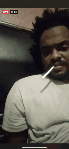 a man in a white shirt is smoking a cigarette in a live video