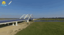 an aerial view of a bridge over a river with a rocket flying in the background