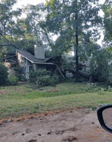 a house that has been damaged by a tree that has fallen on it