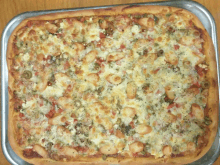 a pizza with a lot of toppings on it is on a pan