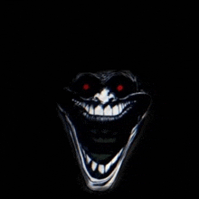 a close up of a creepy troll face with red eyes and a big smile .