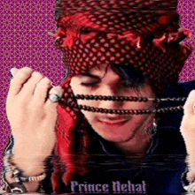 a man wearing a red head scarf and a necklace with the name prince rehal on the bottom