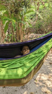 a woman is laying in a hammock on the beach