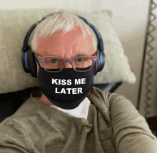 a man wearing headphones and a mask that says " kiss me later "