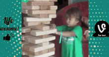 a little boy is playing with a stack of wooden blocks and the words life wesome are on the bottom