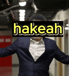 a man in a suit has the word hakeah on his head