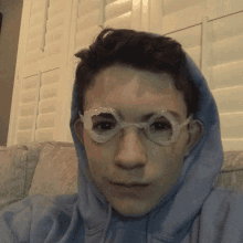 a young boy wearing a blue hoodie and goggles