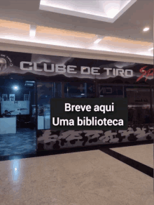 a clube de tiro store with a sign that says breve aqui uma biblioteca on it