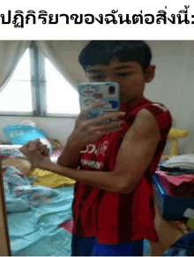 a boy taking a picture of his muscles with a phone with a doraemon cover on it