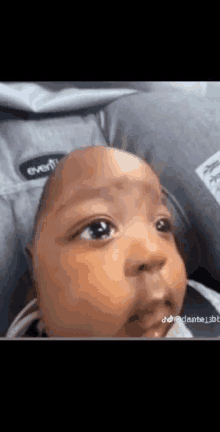 a close up of a baby 's face in a car seat .