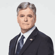 a man in a suit and tie with an american flag pin on his lapel .