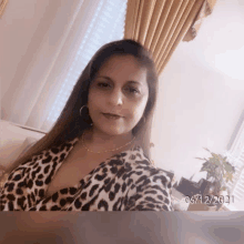 a woman wearing a leopard print shirt takes a selfie on 06/12/2021