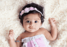 a baby girl wearing a headband with flowers on it