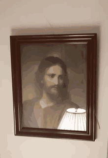 a framed picture of jesus with a lamp in front of him