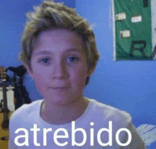 a young boy in a white shirt is making a funny face in a bedroom .