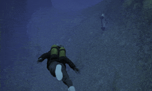 a scuba diver is swimming in the ocean with a green tank on his back