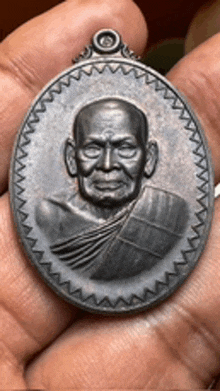 a person is holding a coin with a picture of a monk on it