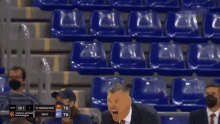 a man in a suit and tie stands in front of empty seats during a game between fc barcelona and zent