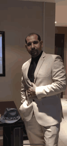 a man in a suit and tie stands in front of a table