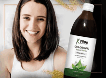 a woman is smiling in front of a bottle of vitae chlorofil liquid form