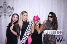 a group of women pose for a photo in a photo booth with a sign that says life is good