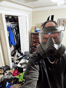 a man wearing a gas mask in a messy bedroom