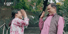 a man and a woman are standing on a set of stairs with loop nepal written on the bottom right