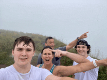 a group of people standing on a hill pointing at something