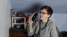 a young man holds a telephone in front of a book that says ' i 'm sorry ' on it