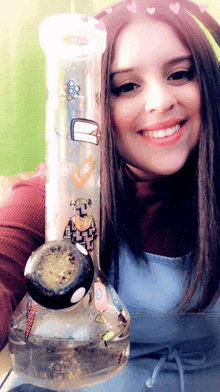 a woman is holding a bong with a cartoon character on it and smiling