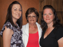 three women posing for a picture with one wearing a red top